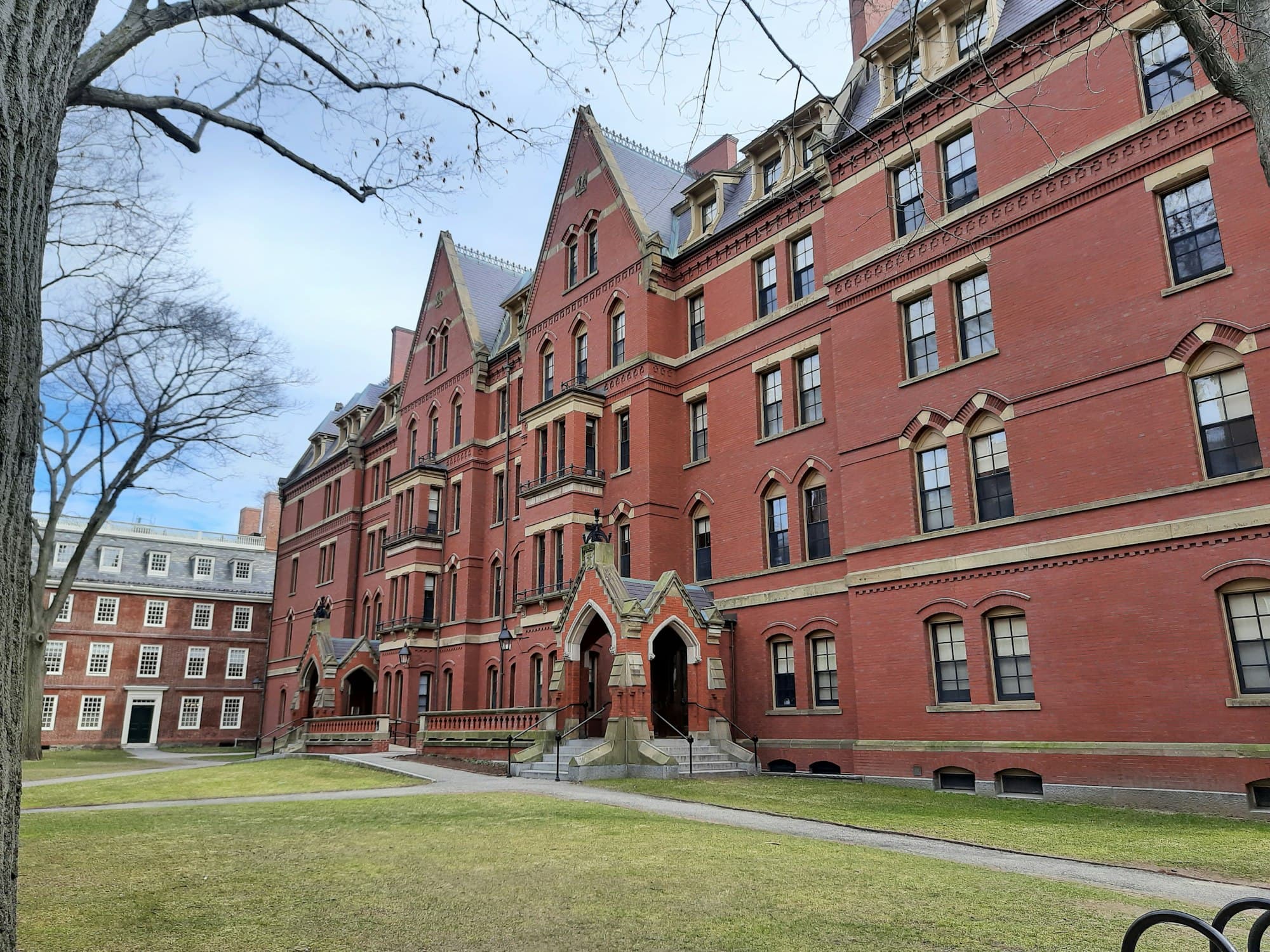 A red-brick university building beside a lawn